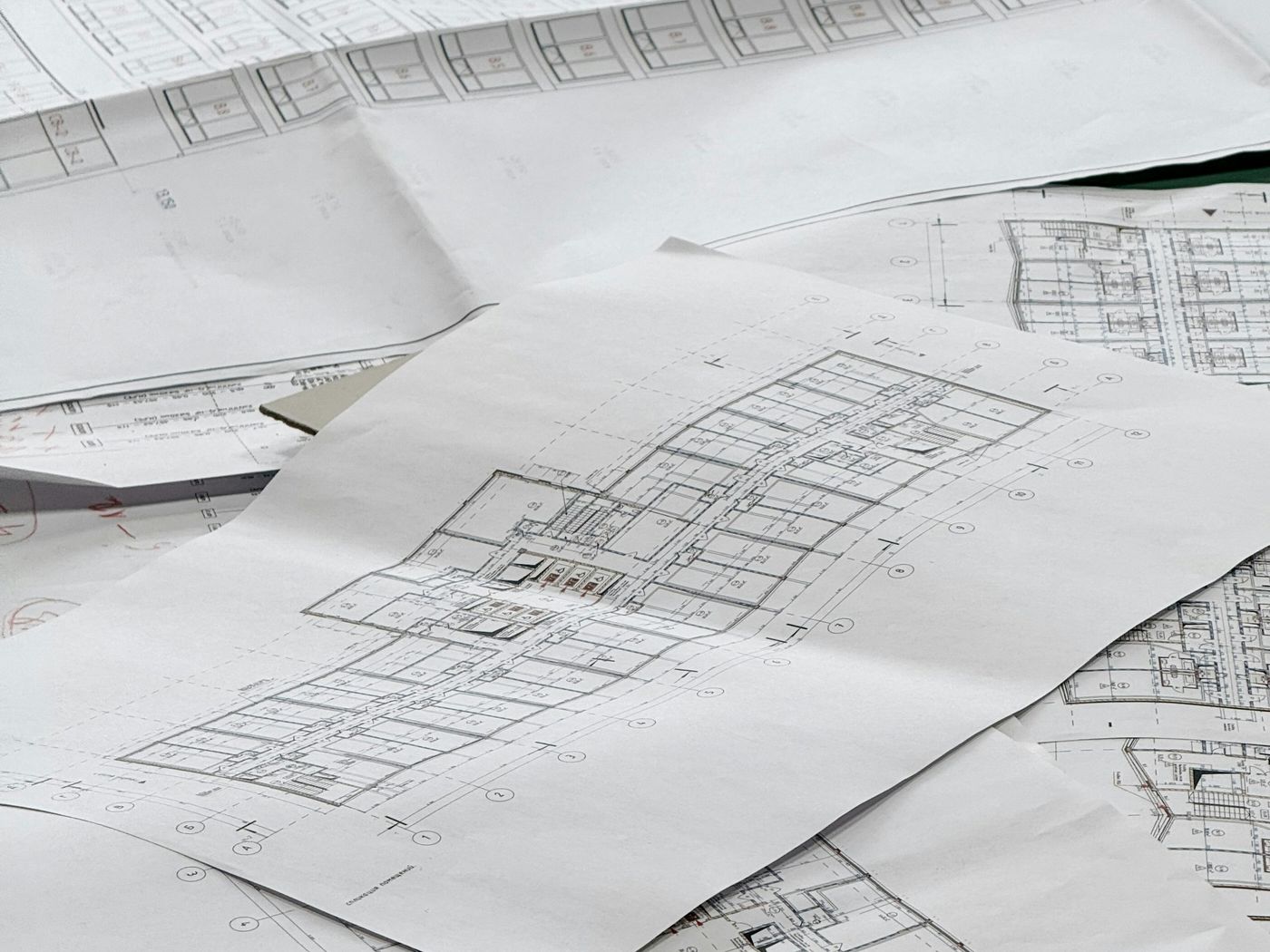 Planos técnicos de edificación extendidos sobre una mesa de trabajo